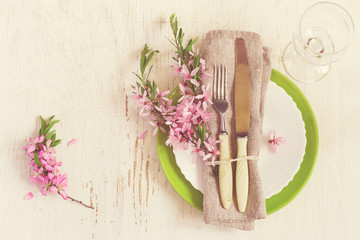 Spring table setting with sprigs of flowering almonds, tinted