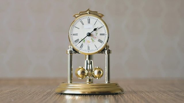 Clock with a pendulum in a form of rotating balls