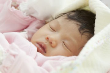 newborn baby sleeping on bed
