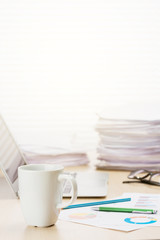 Office workplace with coffee, laptop and supplies