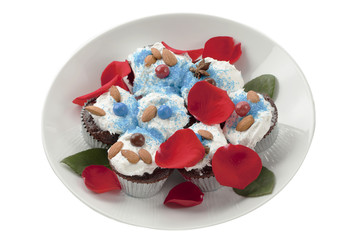 chocolate cupcakes with rose petals on white plate