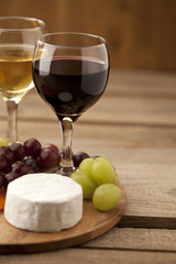 cropped image of grapes with feta cheese and wine glasses.
