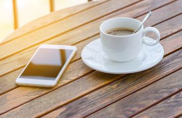 Fototapeta na wymiar coffee cup and smart phone in morning light