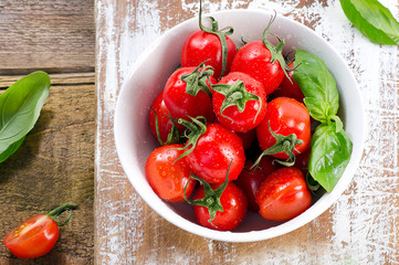 Fresh tomatoes in white bowl.