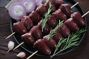 Shish kebabs with raw turkey hearts and seasonings, close-up