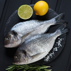 Stone slate tray with fresh uncooked dorado, closeup, above view
