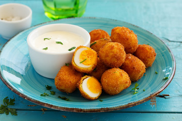 Quail eggs, deep fried with white sauce.