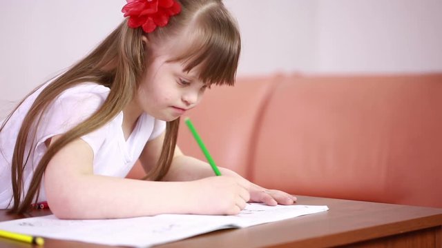 Downs Syndrome girl having speech therapy. Girl with Down syndrome painting