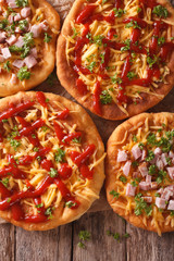 Hungarian langos with cheese, ketchup and ham close-up. Vertical top view
