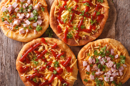 Hungarian langos with cheese, ketchup and ham close-up. horizontal top view
