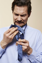 Man getting angry over tie in studio