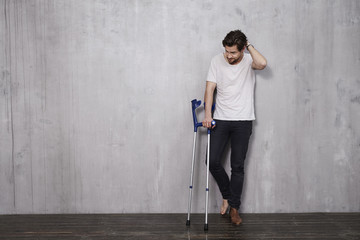 Young man in studio with crutches