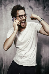 Cheering young man on phone in studio