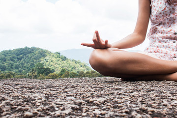 Young woman practicing yoga on natural background