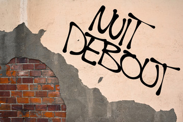 Handwritten graffiti Nuit Debout (Rise up at night) sprayed on the wall, anarchist aesthetics....