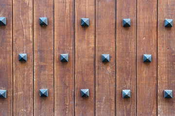 Old wooden wall with decorative rivets