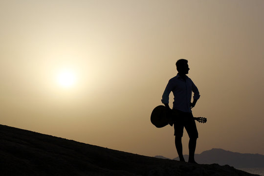 guitarist with guitar and sunrise