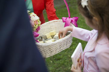 Rozdawanie w koszyku drobnych słodkości dla gości weselnych - obrazy, fototapety, plakaty