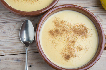 Traditional creme brulee on ceramic dish on wooden table