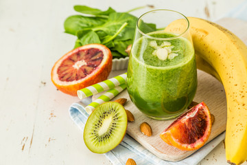 Green smoothie and ingredients on white background