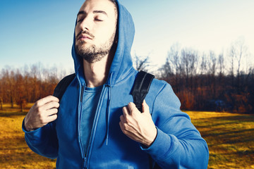 ragazzo con tuta e cappuccio e zaino al parco per sport e relax