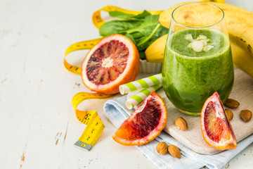 Green smoothie and ingredients on white background