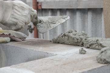 worker aligns with a spatula, lay brick cinderblocks