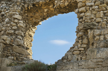 Ruins of ancient Greek sandstone wall with big hole