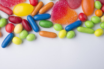 Border of colorful jelly candies on white