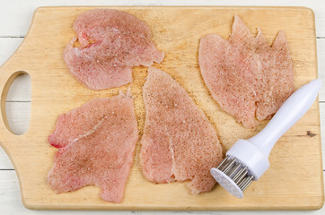 Raw chicken fillets on wooden cutting board