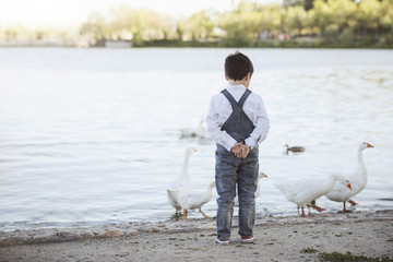 niño pensativo junto al lago