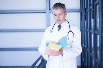 Male doctor reading medical book