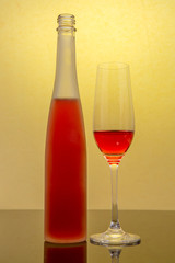 red wine glass and a wine bottles in yellow background
