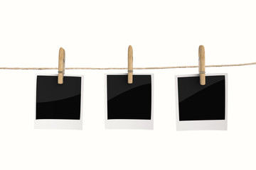 clothespin hanging with blank photo paper on white background