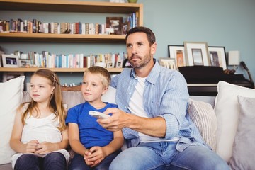 Obraz premium Family watching television while sitting on sofa