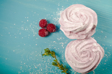 Fresh pink homemade zephyr - marshmallow on blue wooden table. T