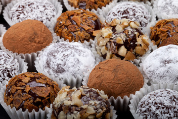 Round homemade chocolates in different kind of decor on paper su
