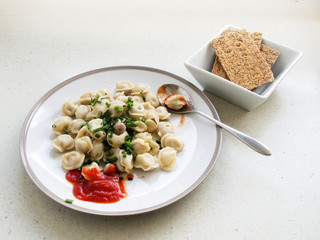 Portion of dumplings and bowl with cracker-bread.