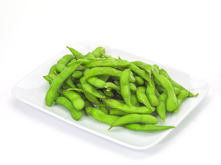 Edamame soy beans in a white ceramic dish.