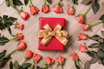 Valentines day background with gift box full of pink roses over wooden table. Top view with copy space