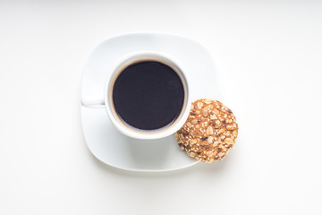 Cup of hot coffee with cookies on white background