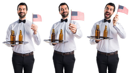 Waiter with beer bottles on the tray holding an american flag