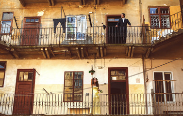 Fototapeta na wymiar Man and woman stand thoughtfully on balconies on the different f