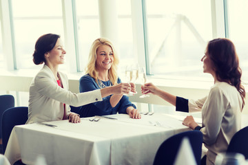 Fototapeta premium happy women drinking champagne at restaurant