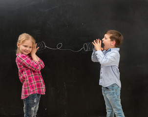 two funny children talking on self-made drawn telephone