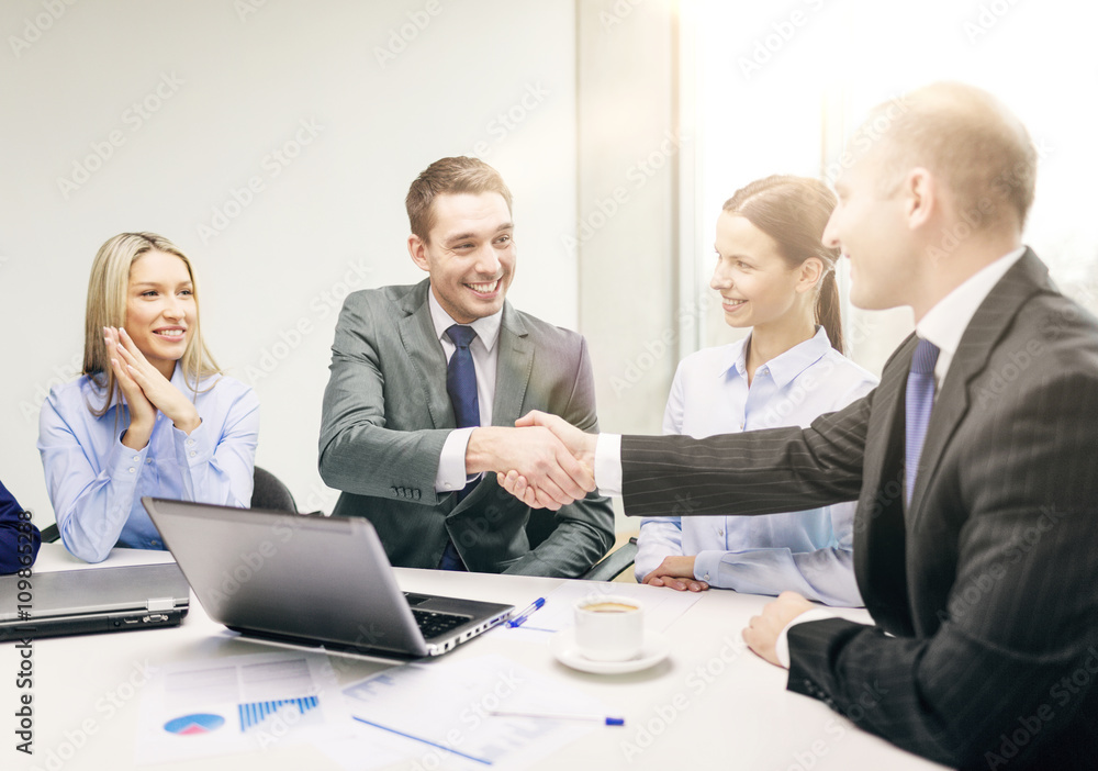 Wall mural two businessman shaking hands in office