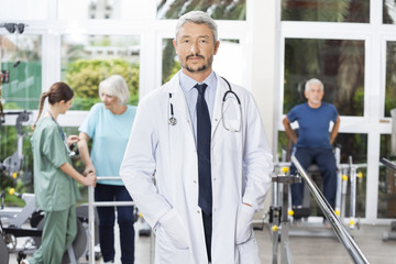 Obraz premium Confident Male Physiotherapist Standing In Rehab Center