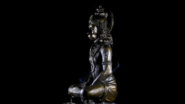 Hanuman figure, god monkey of hindu religion, gyrating at black background