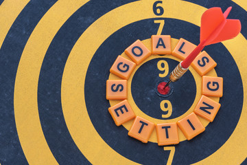 Words goals setting and dart target arrow on the bullseye of dartboard, Smart goal target success...