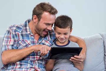 Father and son using digital tablet